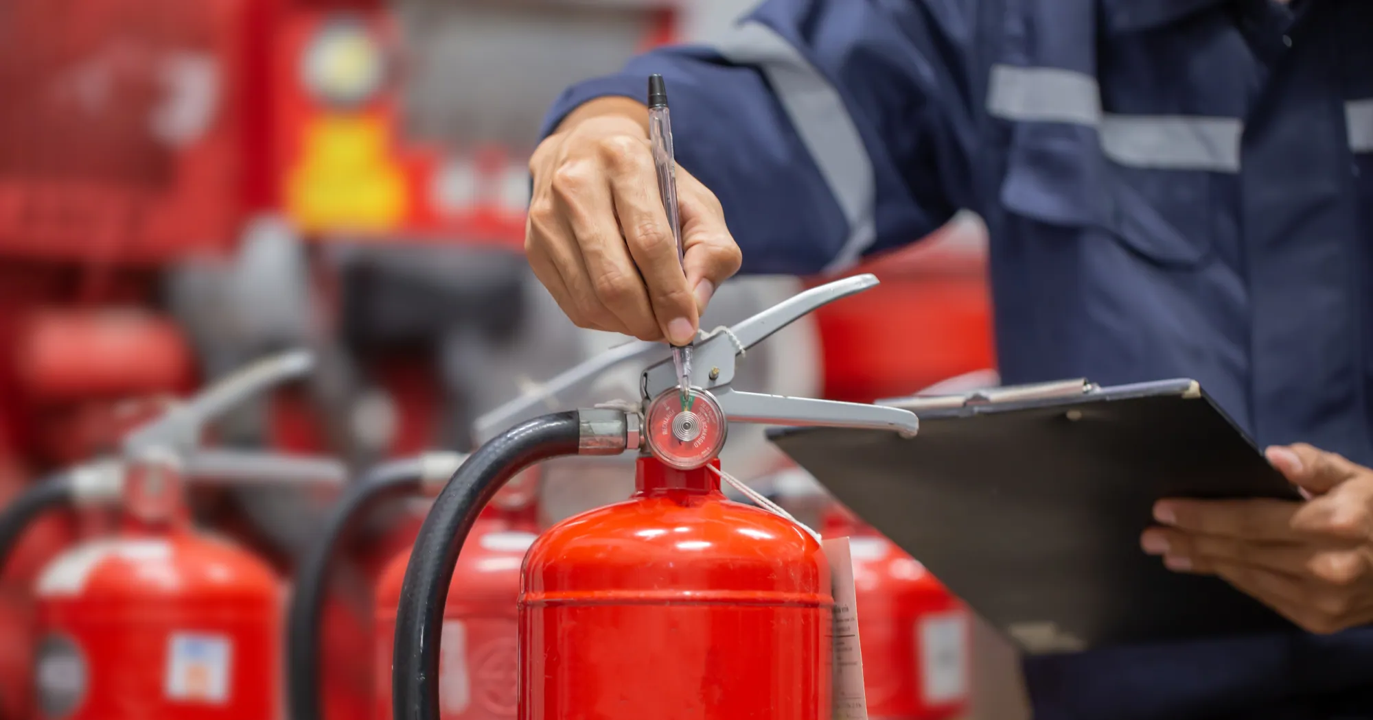 Technician inspecting a portable fire extinguisher